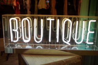 Neon sign displaying the word 'BOUTIQUE' in bright letters, showcasing a stylish boutique atmosphere.