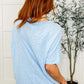 Woman showcasing the back of the Layback Relaxed Basic Tee in Light Blue, featuring a slouchy fit and relaxed style.