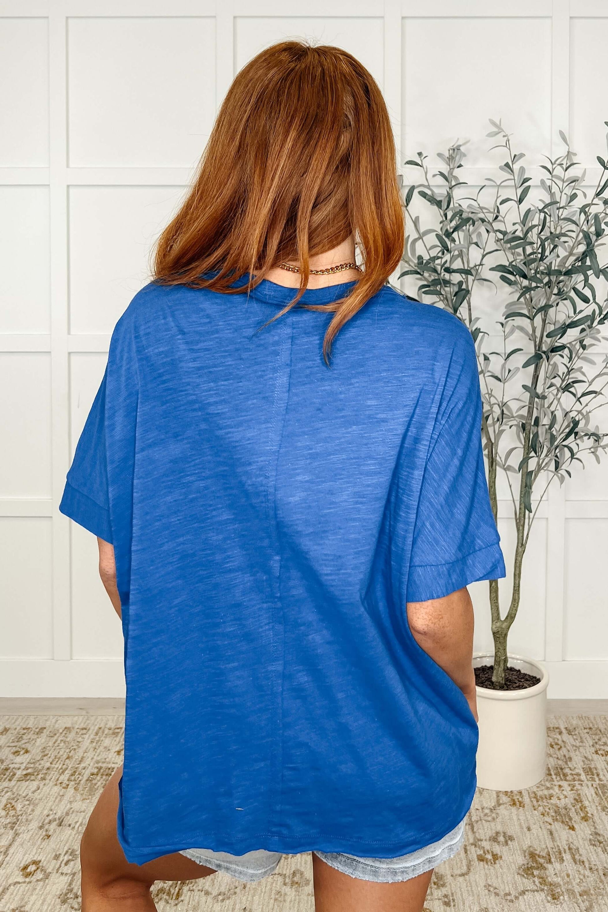 Woman wearing the Layback Relaxed Basic Tee in Royal Blue, showcasing the back view with a relaxed fit.